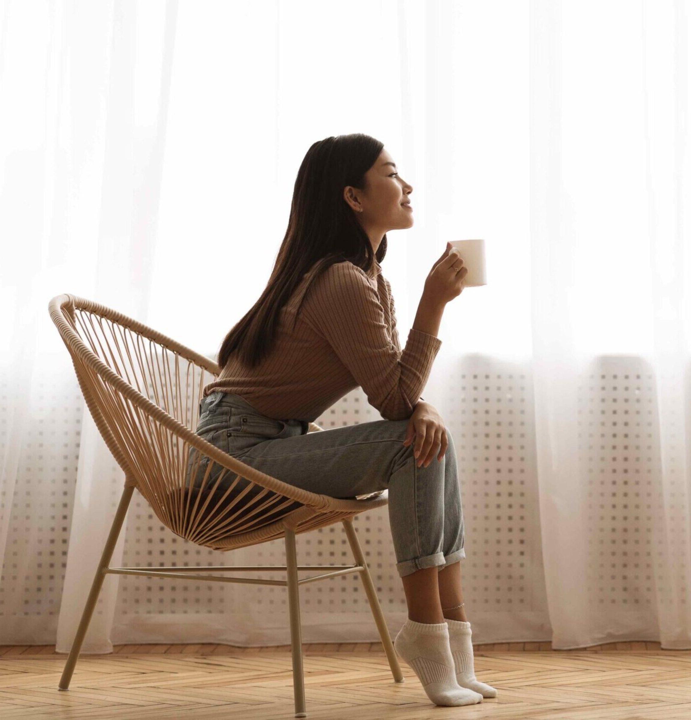 女孩坐在扶手椅上享受咖啡